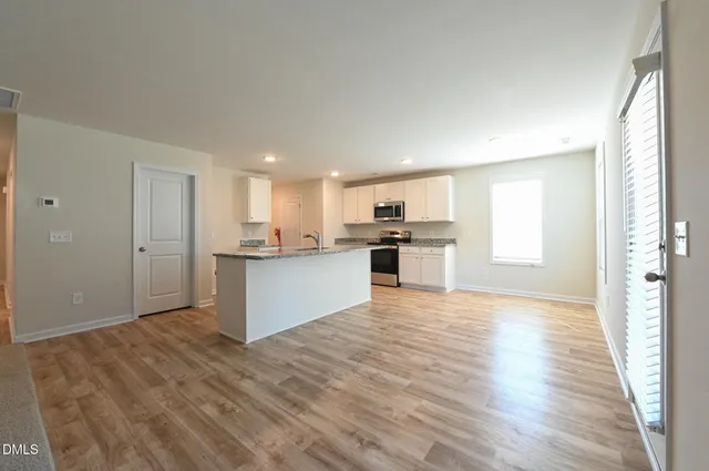 a kitchen with stainless steel appliances kitchen island granite countertop a stove a sink and a refrigerator