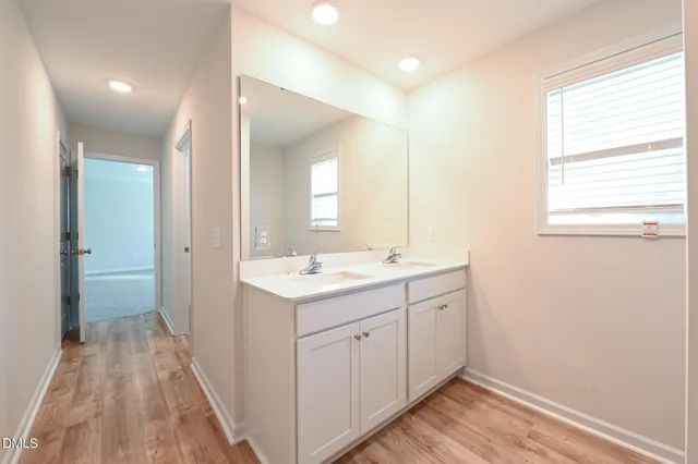 a bathroom with a tub shower vanity and a sink