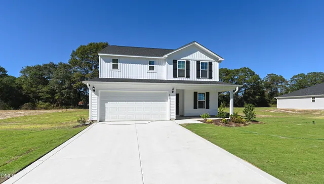 a front view of a house with a yard and trees
