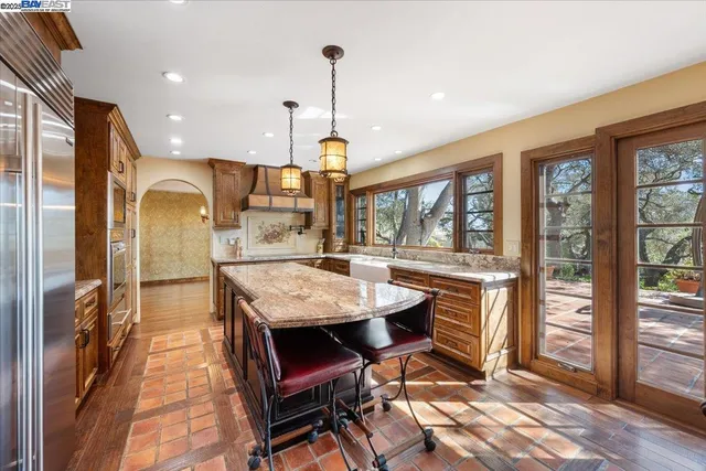 a kitchen with stainless steel appliances granite countertop table chairs and wooden floor