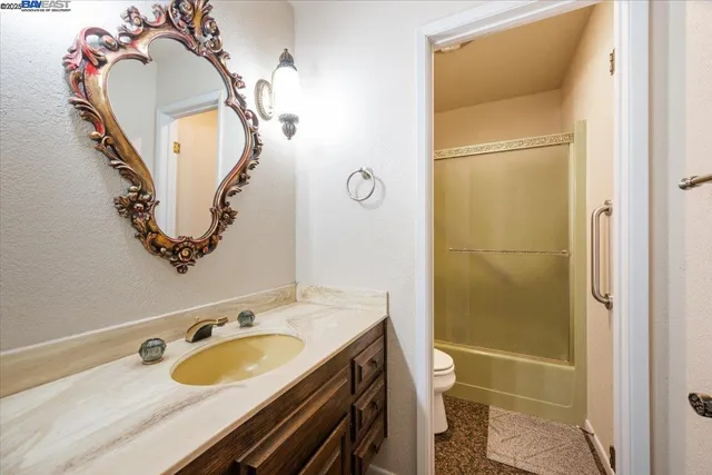 a bathroom with a granite countertop sink toilet and shower