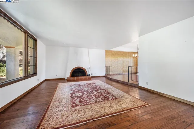 a view of a bedroom with wooden floor and window
