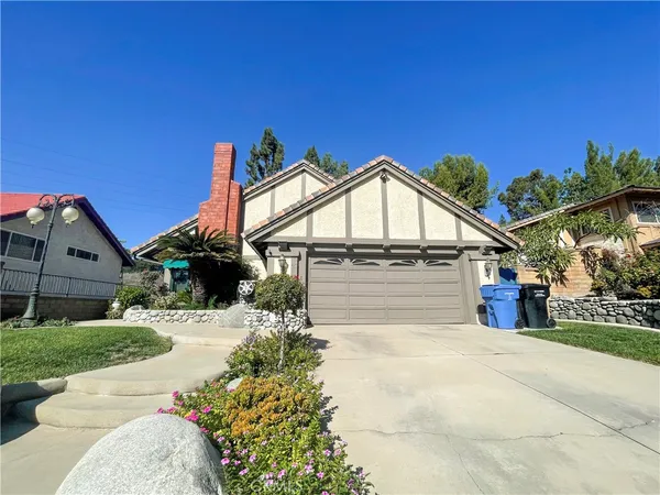 a view of a house with a yard and potted plants