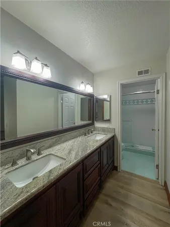 a bathroom with a granite countertop sink and a large mirror