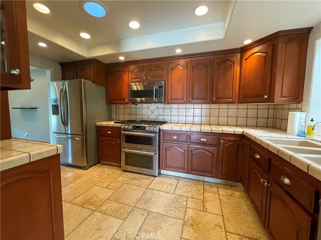 a kitchen with stainless steel appliances granite countertop a stove sink and cabinets