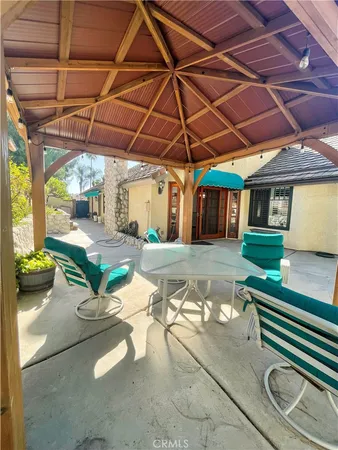 a view of a patio with a table and chairs under an umbrella