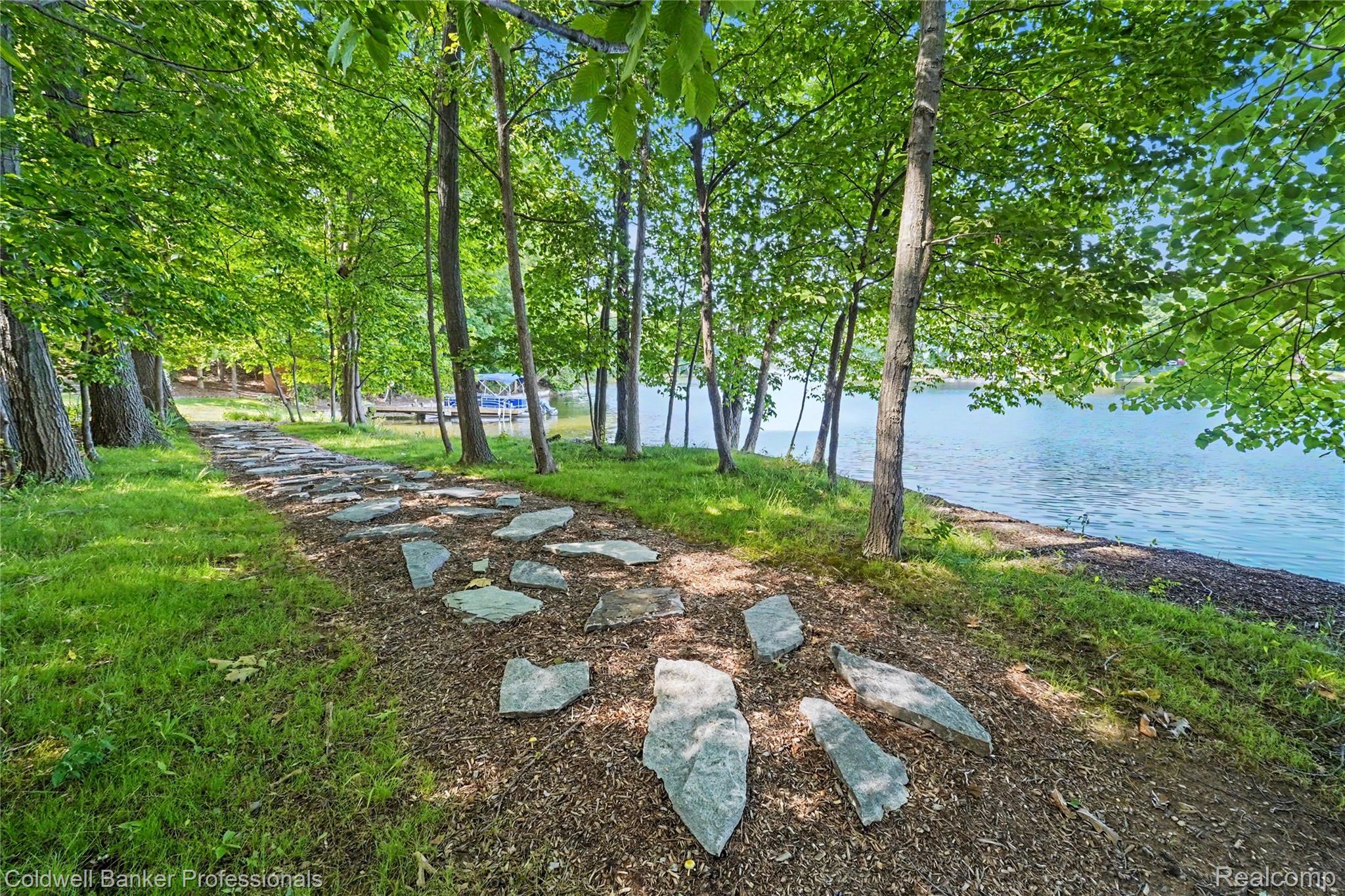 3583 Mitchell Road Metamora, MI 48455 - Photo 55 of 58 Stone pathway leading to a waterfront area with mature trees and a dock