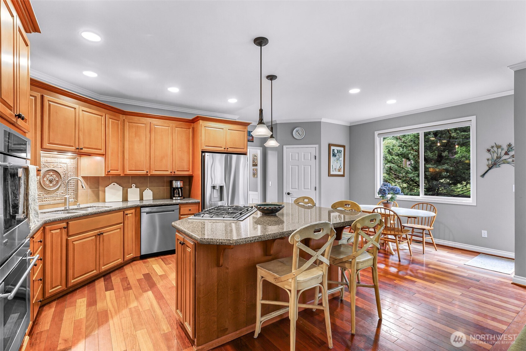 2029 240th Place Southeast Bothell, WA 98021 - Photo 10 of 39 a kitchen with stainless steel appliances granite countertop wooden floor window dining table and chairs