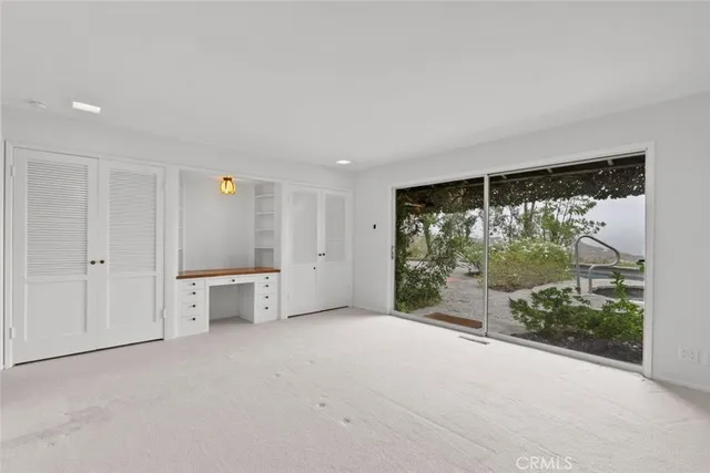 an empty room with windows and closet