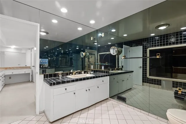 a bathroom with a sink toilet vanity and shower