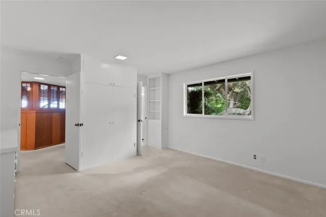 a view of an empty room with wooden floor and a cabinet