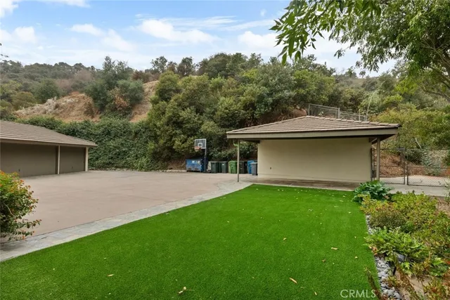 a swimming pool view with a table and chairs under an umbrella