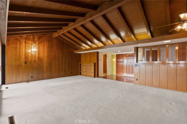 a view of an empty room with a fireplace and a window