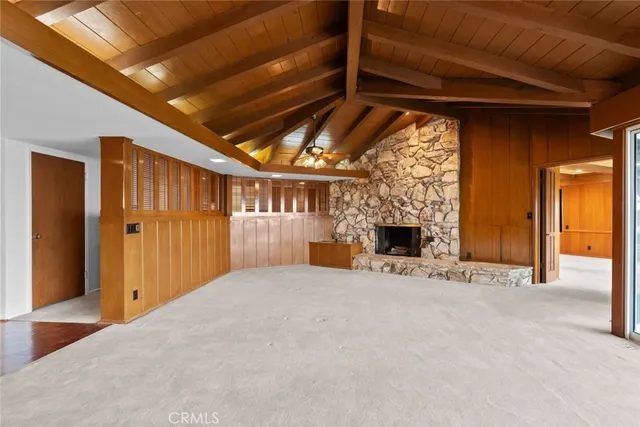 a view of an empty room with a fireplace and a window