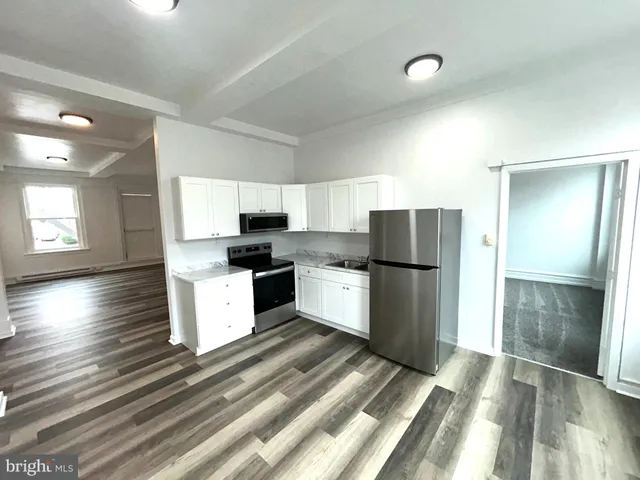 a kitchen with a refrigerator and a stove top oven