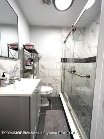 a bathroom with a sink a toilet and shower