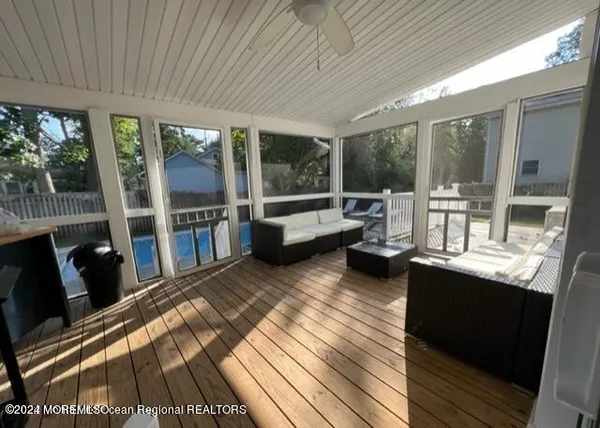 a living room with furniture a flat screen tv and a floor to ceiling window