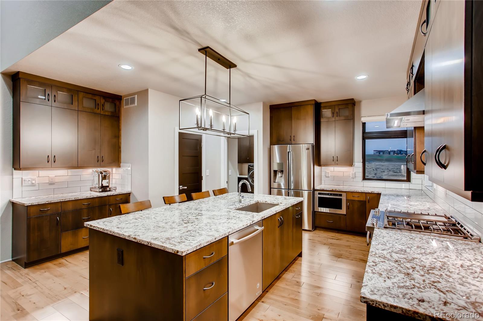 2147 Picture Point Drive Windsor, CO 80550 - Photo 17 of 39 a kitchen with stainless steel appliances kitchen island granite countertop a sink stove and refrigerator