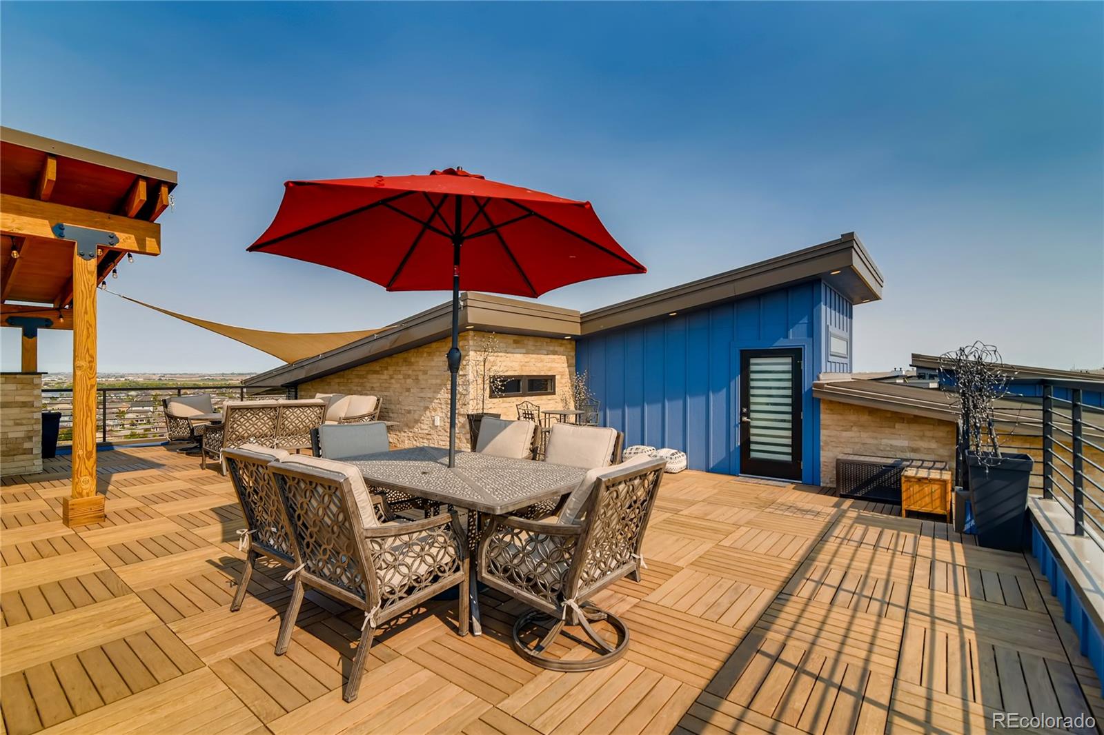 2147 Picture Point Drive Windsor, CO 80550 - Photo 39 of 39 a view of a roof deck with table and chairs under an umbrella with wooden floor