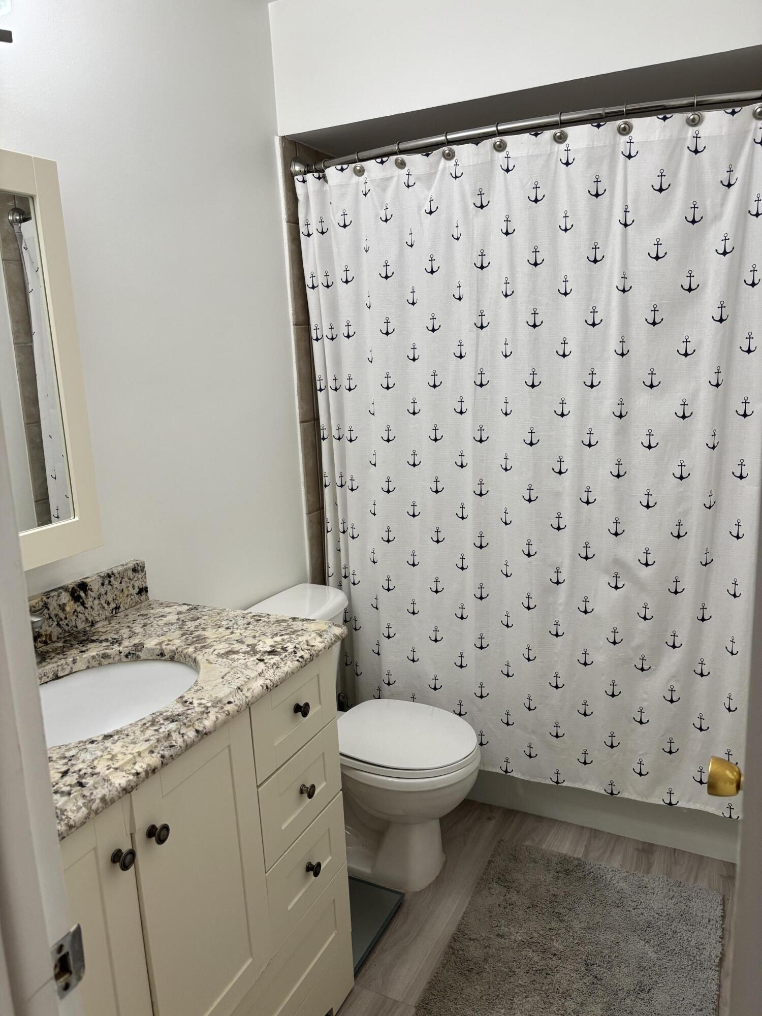 5505 North Ocean Boulevard, Unit 3204 Ocean Ridge, FL 33435 - Photo 16 of 33 a bathroom with a granite countertop sink a toilet and a mirror