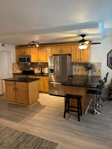 a kitchen with granite countertop a sink cabinets and stainless steel appliances