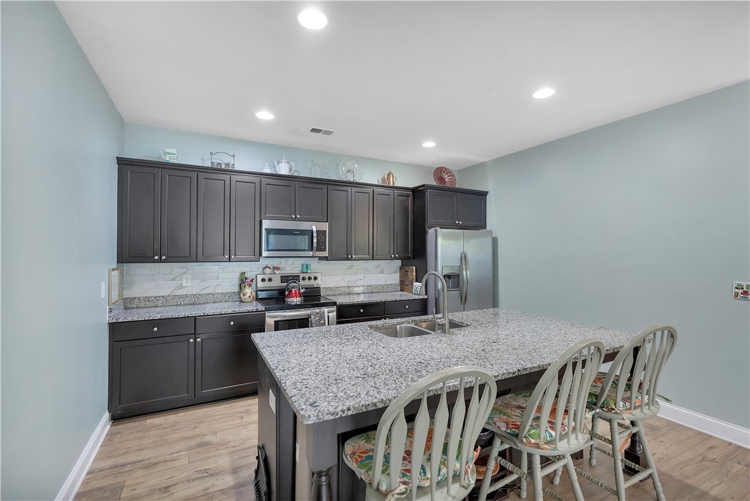121 Ventura Street Anderson, SC 29621 - Photo 9 of 32 A well-appointed kitchen features rich dark cabinetry, sleek granite countertops, and modern stainless steel appliances.