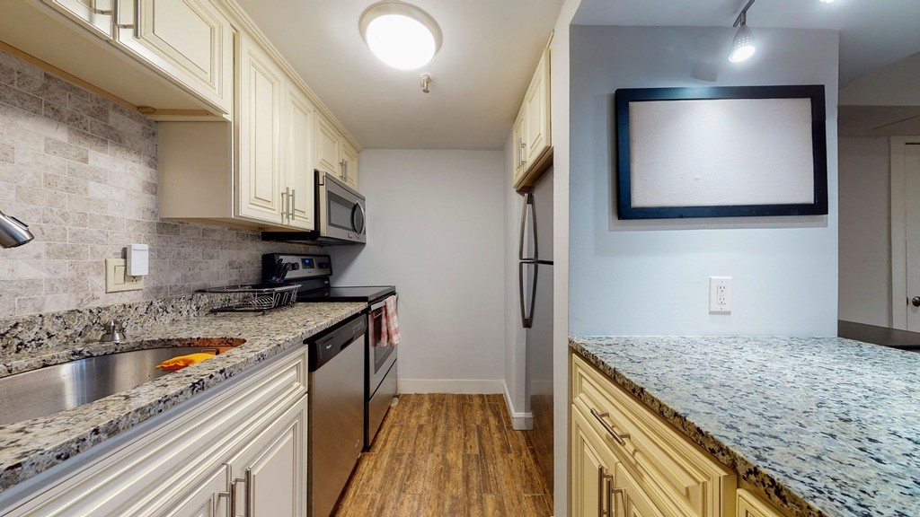 a kitchen with stainless steel appliances granite countertop a sink stove and refrigerator