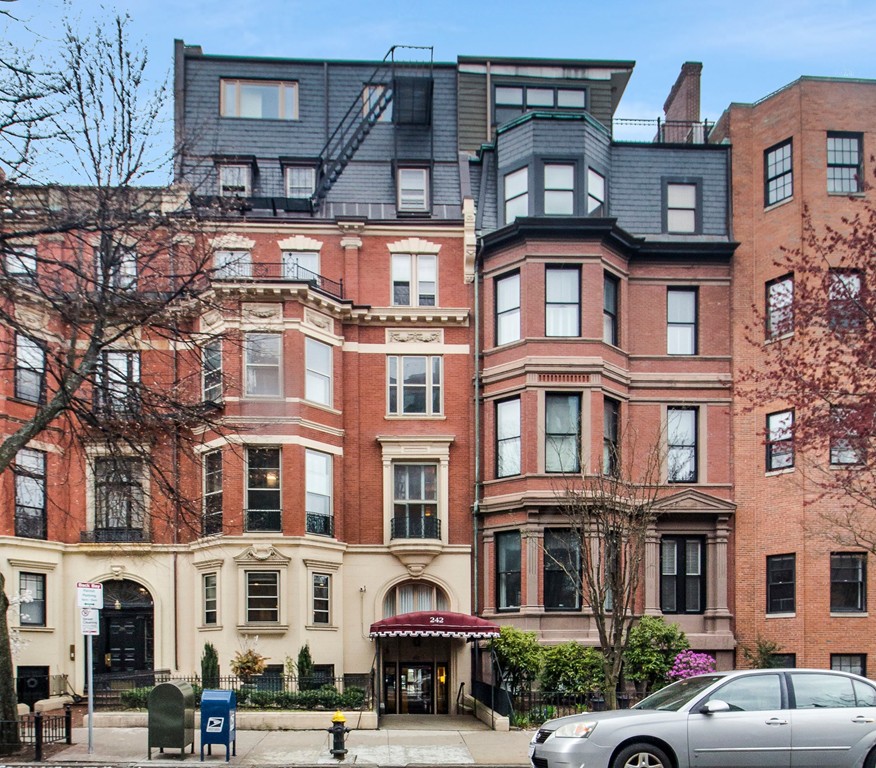242 Beacon Street, Unit 2 Boston, MA 02116 - Photo 9 of 10 a front view of a building with lot of cars and trees