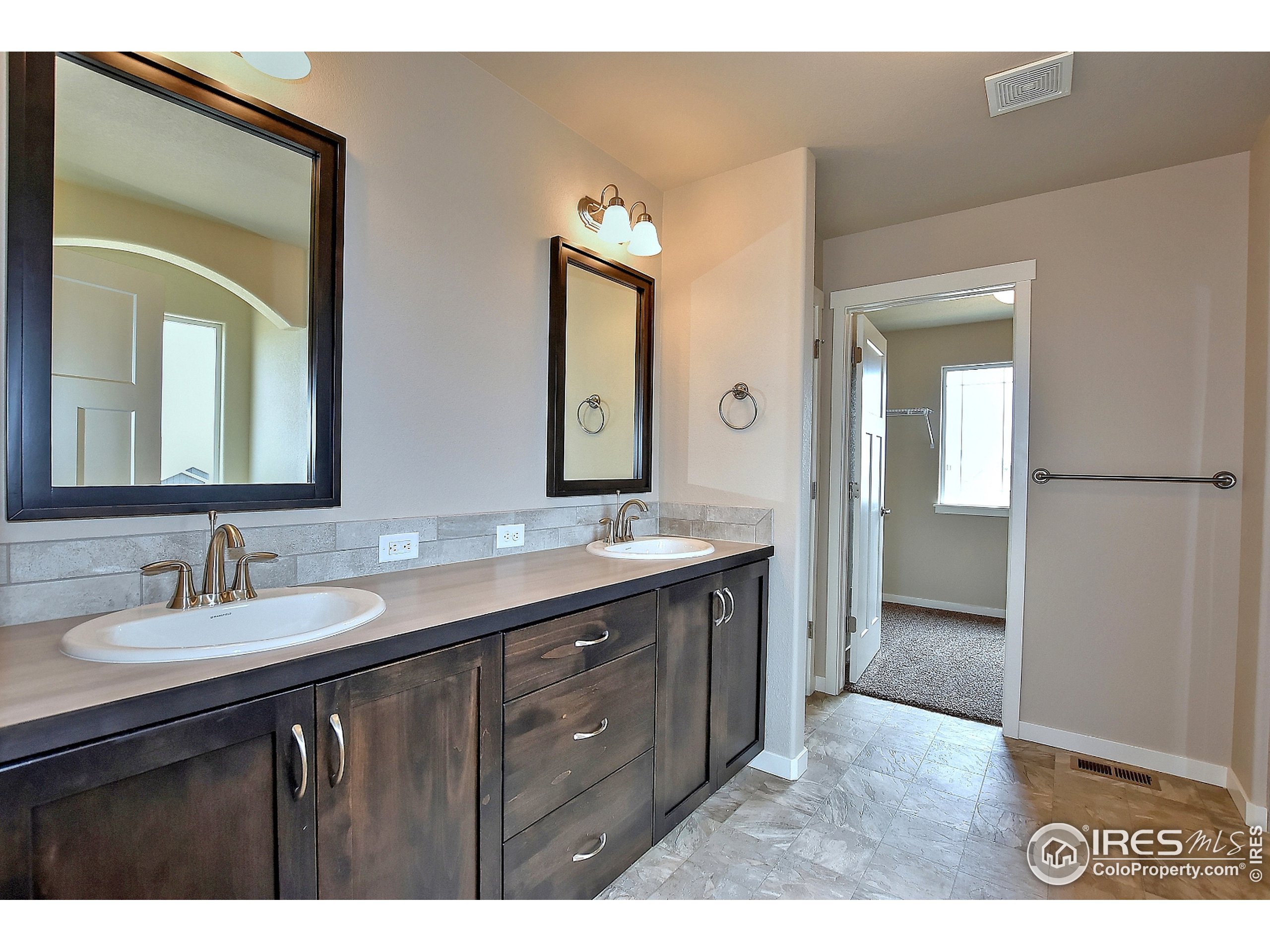 6630 Pebble Path Court Timnath, CO 80547 - Photo 11 of 18 a bathroom with a double vanity sink and a mirror