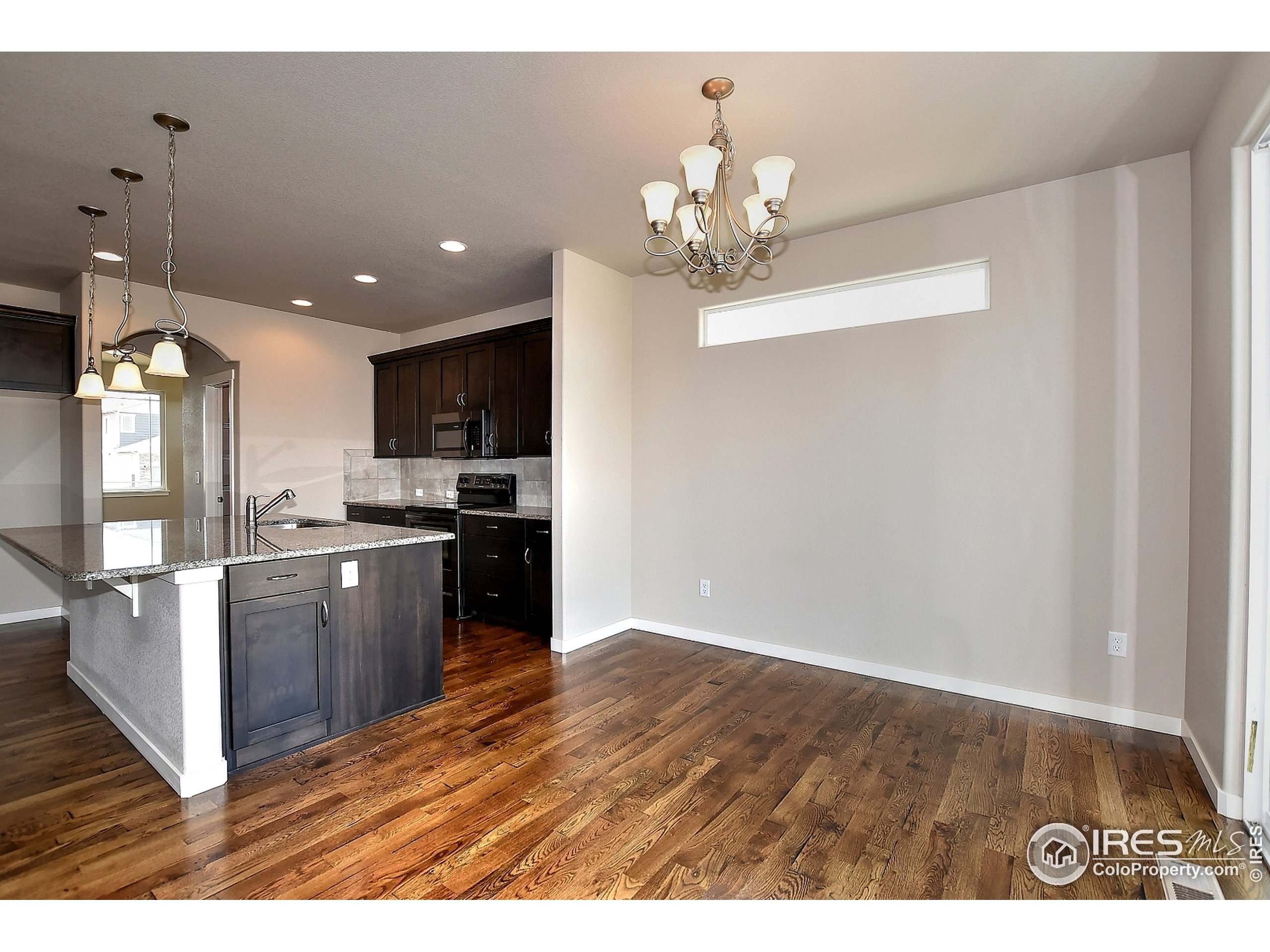 6630 Pebble Path Court Timnath, CO 80547 - Photo 2 of 18 a kitchen with kitchen island granite countertop stainless steel appliances cabinets a sink and a counter top space