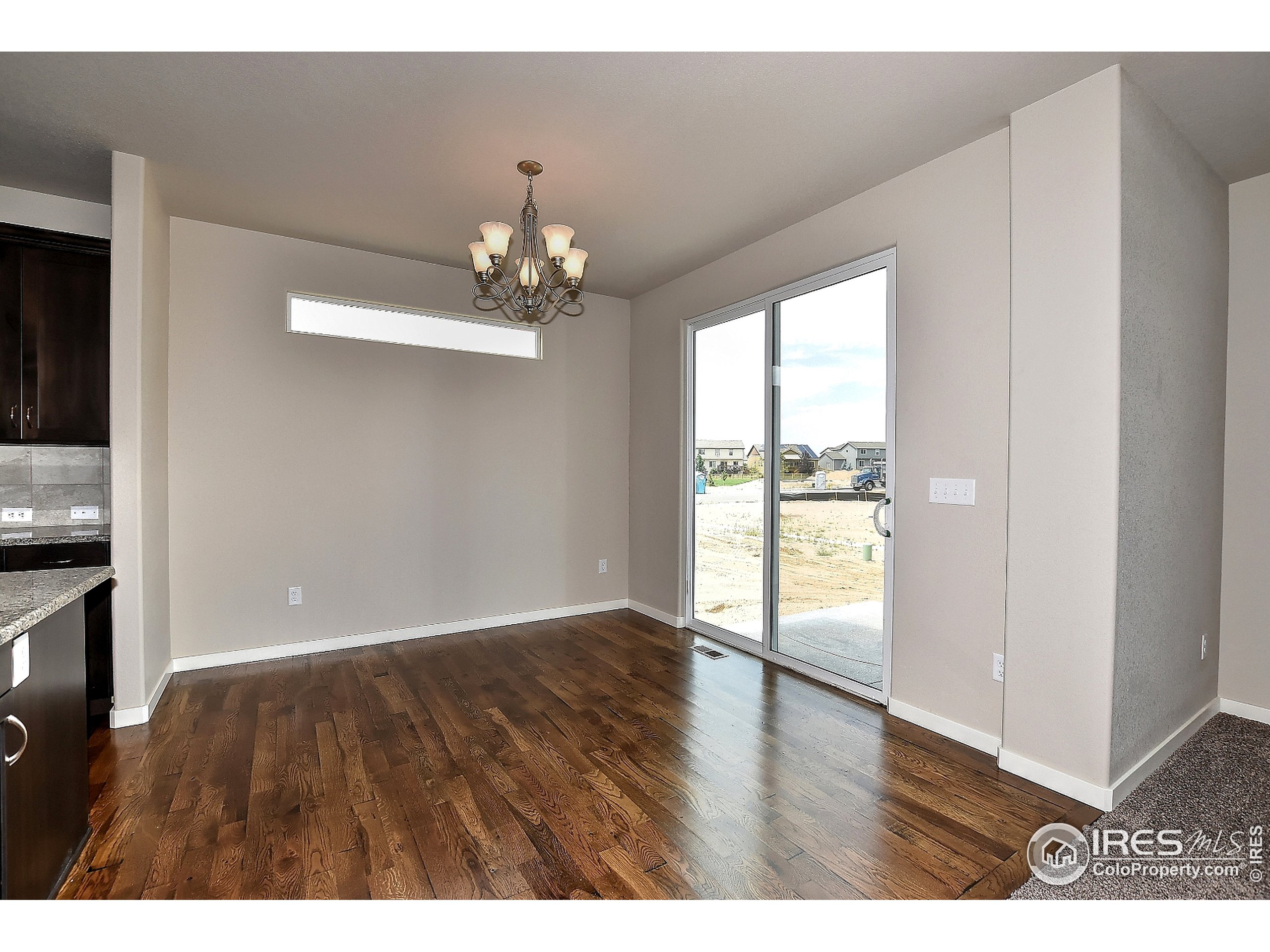 6630 Pebble Path Court Timnath, CO 80547 - Photo 5 of 18 a view of an empty room with wooden floor and a window