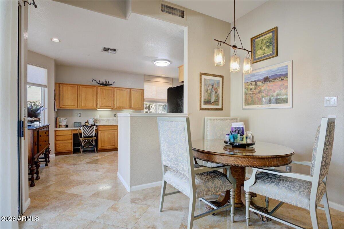 4906 East Wagoner Road Scottsdale, AZ 85254 - Photo 7 of 29 a kitchen with stainless steel appliances a dining table chairs refrigerator and cabinets