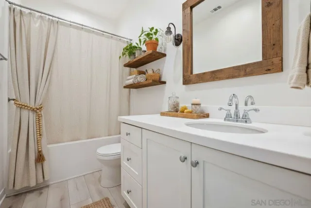 a bathroom with a sink a toilet and shower curtain