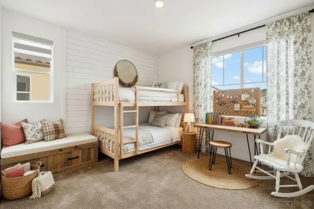 a bedroom with a bed and large windows