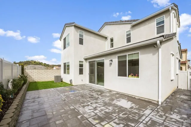 a view of a house with a yard and potted plants