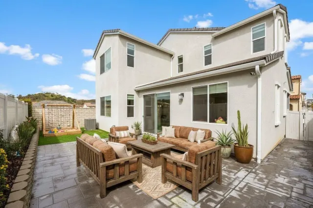 a view of a patio with couches table and chairs and potted plants