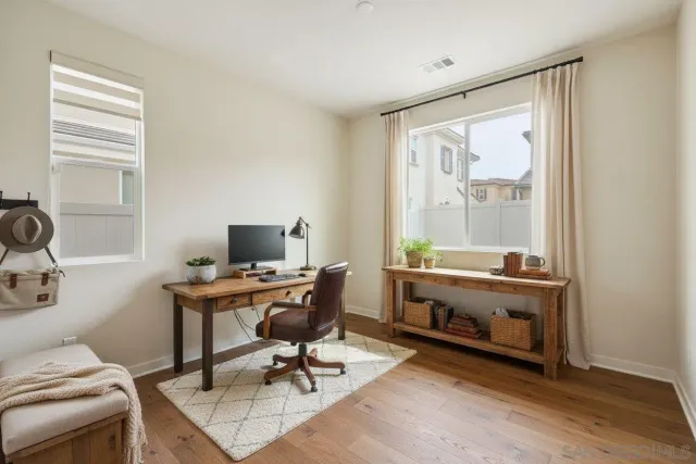 a view of a workspace with furniture and a window