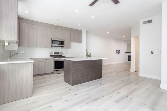 a kitchen with a sink a counter top space and stainless steel appliances