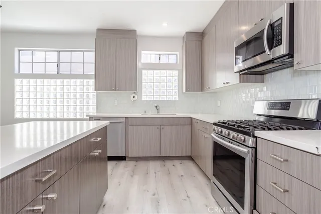 a kitchen with stainless steel appliances granite countertop a stove a sink and a microwave