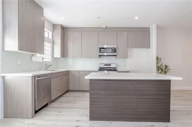 a kitchen with kitchen island granite countertop a sink window and cabinets