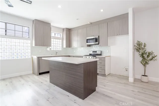 a kitchen with kitchen island white cabinets and window
