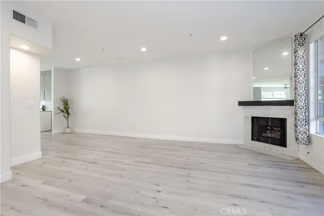 a view of empty room with wooden floor and fireplace