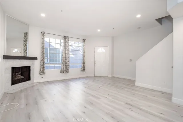 a view of an empty room with a fireplace and a window