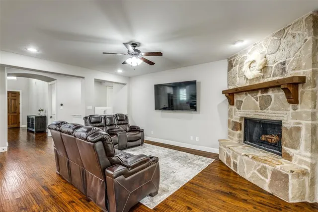 a living room with furniture a flat screen tv and a fireplace