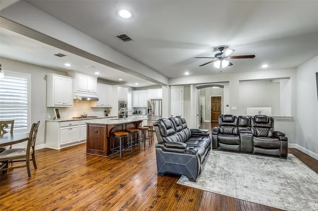 a living room with furniture kitchen view and a chandelier