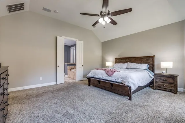 a spacious bedroom with a bed and a chandelier