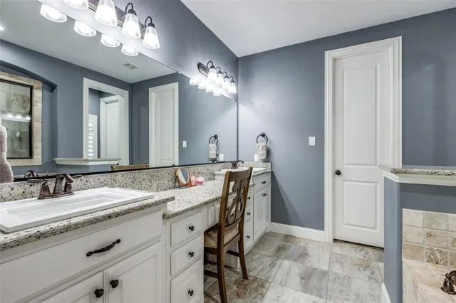 a bathroom with a granite countertop sink a large mirror and a shower