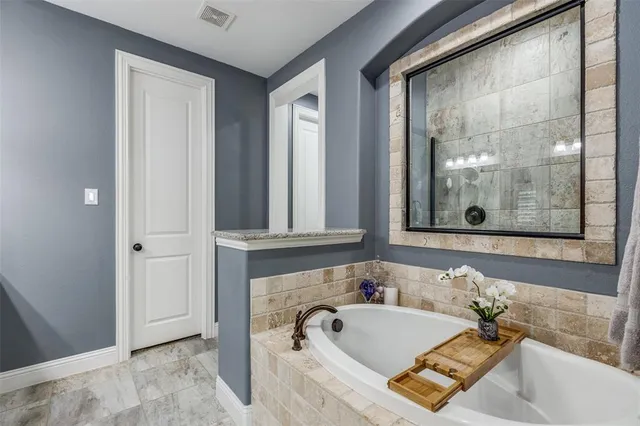a bathroom with a tub sink and mirror