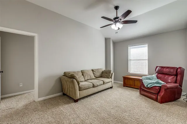 a living room with furniture and ceiling fan