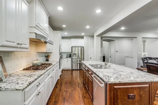 a kitchen with stainless steel appliances granite countertop a sink stove and refrigerator